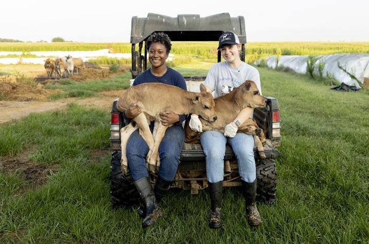 Students holding two baby calves that were just born during their U-DAIRE shift Students holding two baby calves that were just born during their U-DAIRE shift