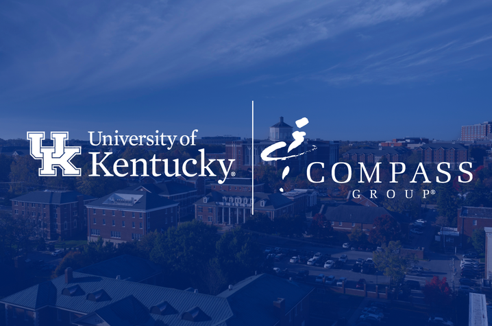  Kentucky and Compass Group logos over a blue‑tinted aerial view of campus buildings