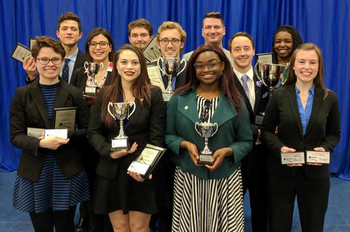 Photo of UK Speech and Debate Team posing with trophies. 