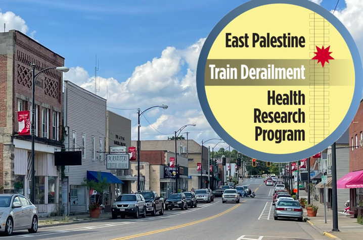 Main Street in East Palestine, Ohio, with small businesses and cars lined along the road. A yellow circular graphic overlays the scene reading “East Palestine Train Derailment Health Research Program."