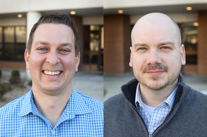Side-by-side headshots show two men smiling outdoors in front of a building entrance. One wears a blue checkered shirt, while the other wears a gray zip-up sweater over a collared shirt.