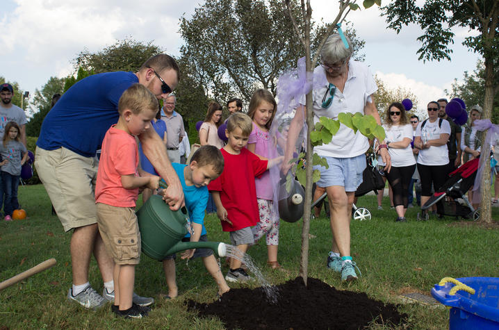 photo of children planting and watering a tree