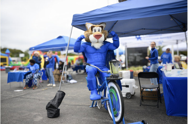 Image of wildcat mascot on a bike