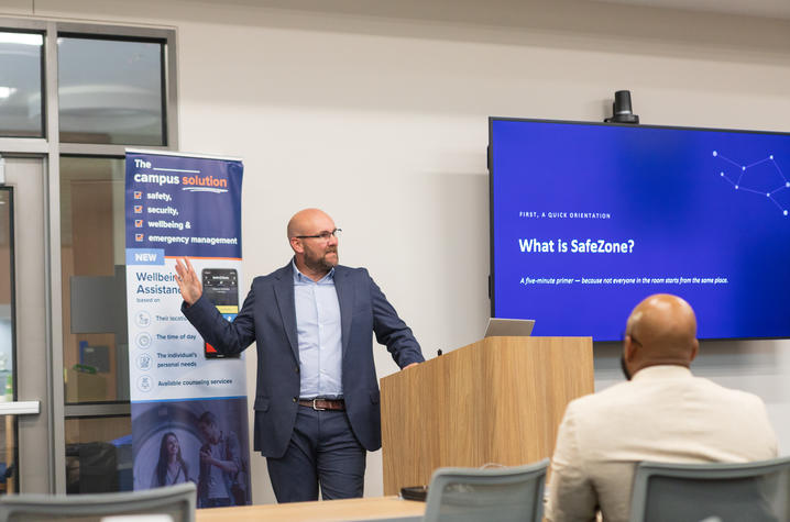 Critical Arc’s Darren Chalmers-Stevens speaks at a podium during a session titled “What is SafeZone?” as attendees listen in a University of Kentucky meeting room.