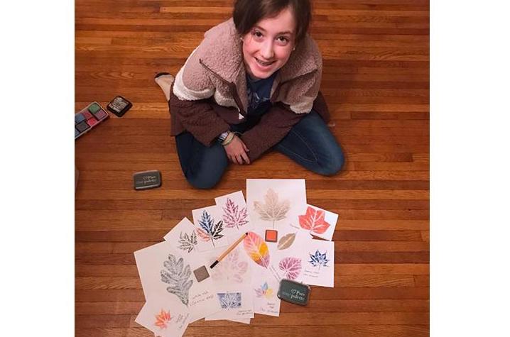 Brenna Mefford shows off her leaf print collection that she made in another 4-H program. 4-H'ers who become Junior Master Naturalists will make a similar collection