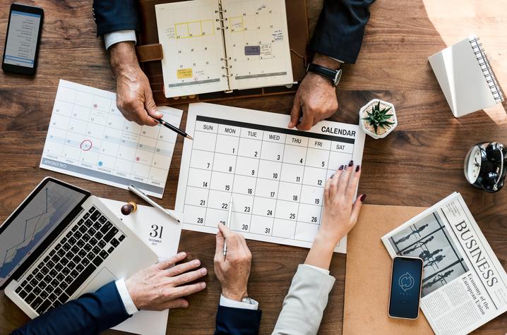 People looking at a calendar. 