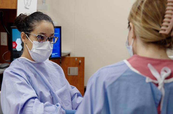 Marcia speaking with a dental student