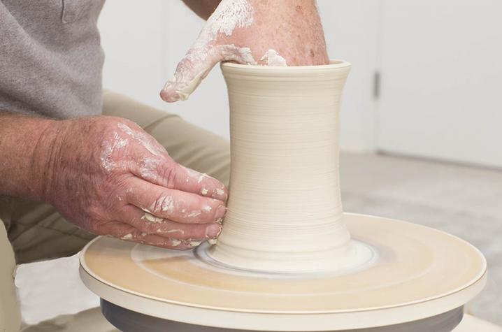 photo of hands work on ceramic vase - Fine Arts Institute