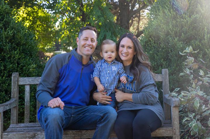 Image of Cameron and his parents Jeff and Jessica Fugate sitting on a bench