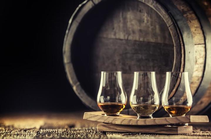 Glasses of whisky in front of barrel 