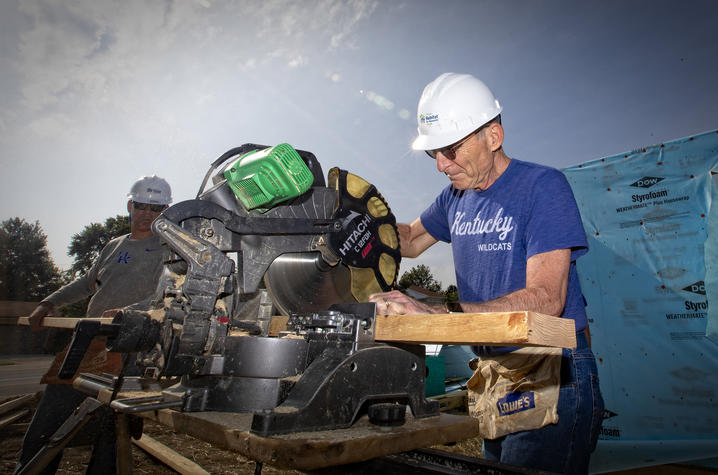 photo of President Capilouto sawing wood