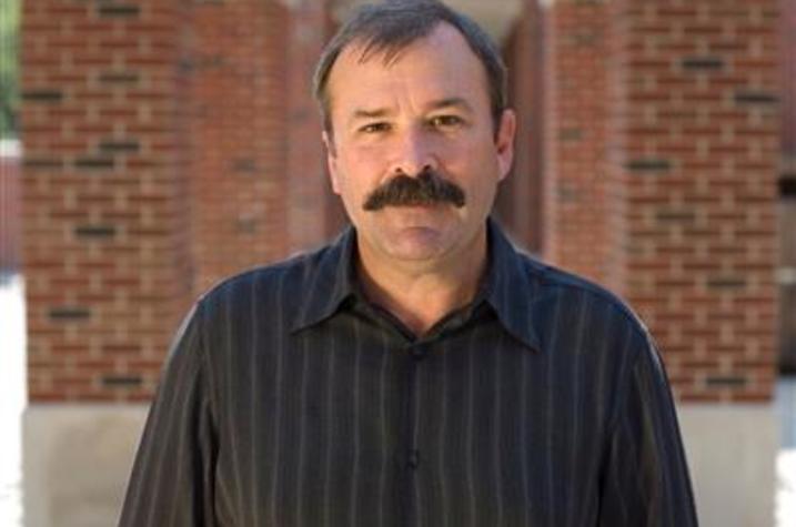 photo of James Campbell standing between 2 rows of brick columns