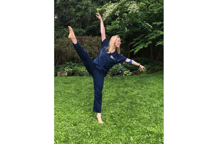 photo of Katelyn Cox dancing in scrubs in yard