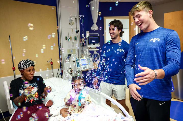 Image of football players and patient playing with bubbles