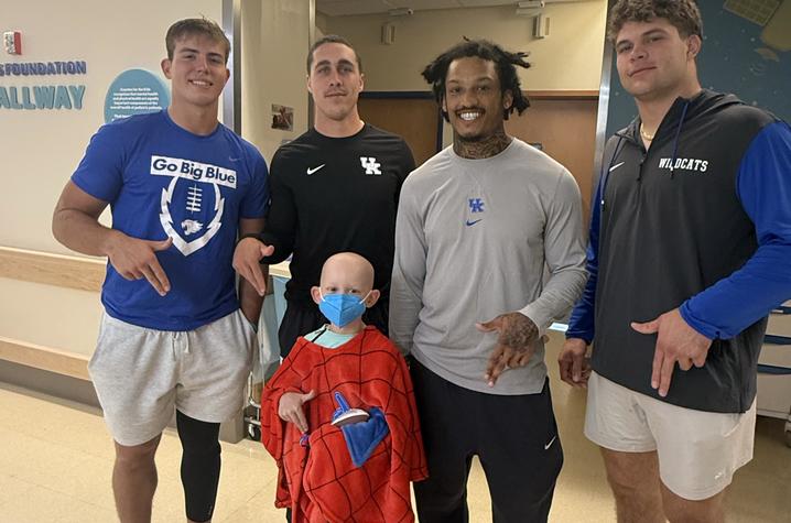 Image of football players posing with a patient