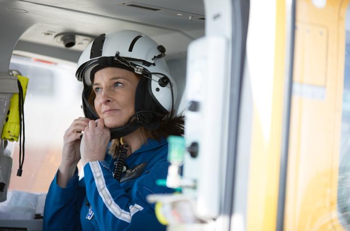 deb rice inside the helicopter buckling her helmet