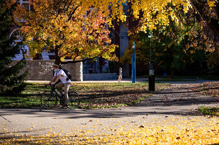 Campus trees and student on bicycle