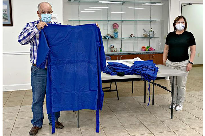 Steve Arnold (left) and Sherrill Bentley (right) show gowns completed by extension volunteers.