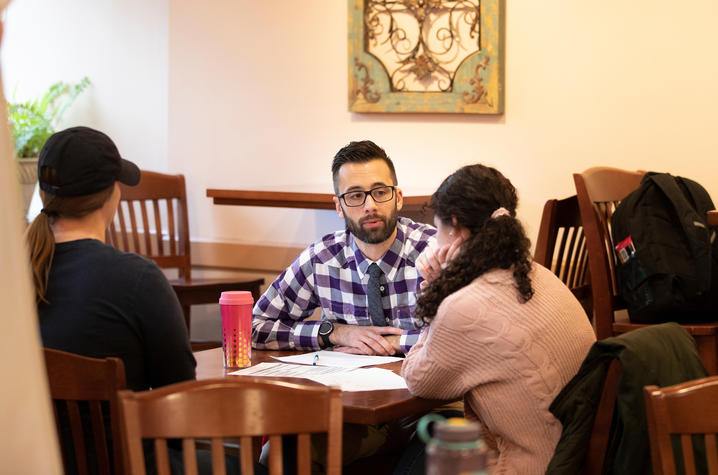 Aaron Schwartz seated at table speaking to two students