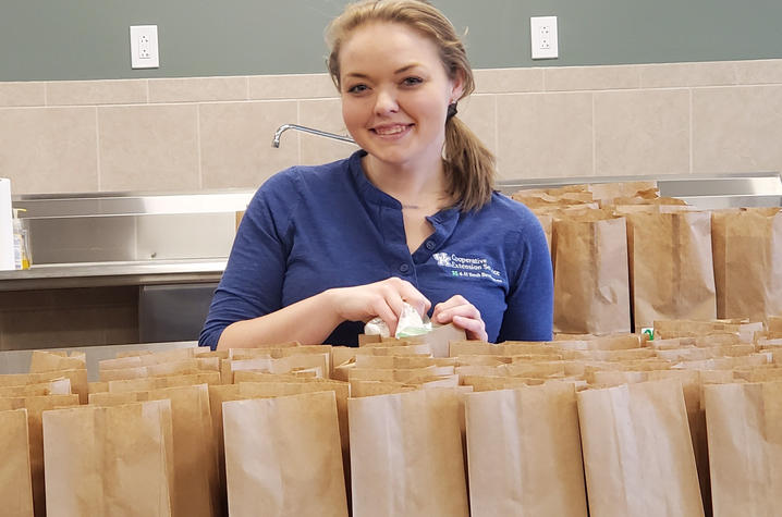 Melissa Schenck poses with brown bags