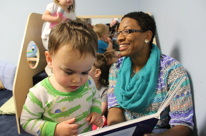 Stefani Whaley, a health and safety coach with Child Care Aware of Kentucky,  shares a book with a child during a technical assistance visit.