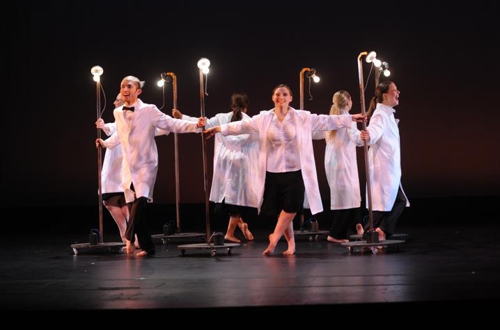 photo of circle of 6 dancers (including Alyssa Noell Conley) in white coats with light bulbs performing "Always Carry a Light Bulb"