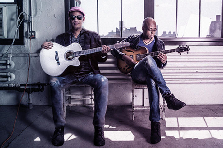 photo of Raul Midon and Lionel Lueke with their guitars seated on bench