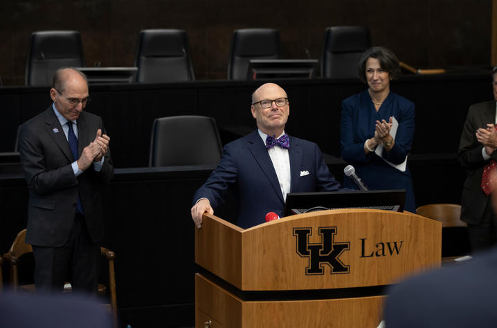 J. David Rosenberg standing behind podium in suit