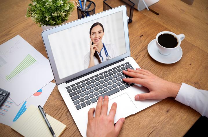 photo of man talking to doctor via computer