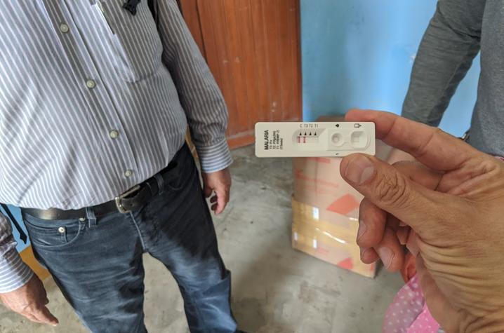 Kip Guy holds the malaria diagnostic test in the remote clinic in Peru. Patients here often present with both types of malaria, which will help the research team test the new drug against both strains.