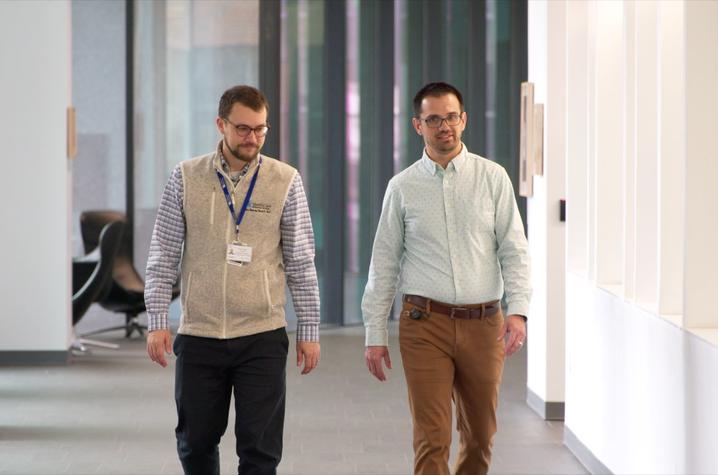 Doug Oyler walking down the hallway with a College of Pharmacy colleague