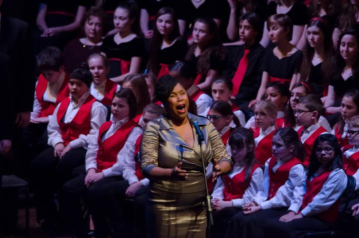 photo of Angelique Clay singing solo in front of Lexington Singers Chidren's Choir a Collage