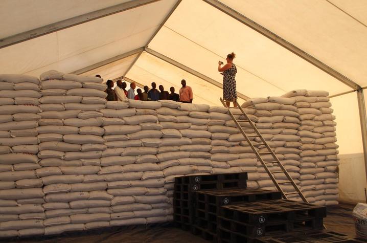 Marshall stands atop bags of sorghum before distribution to people in need.