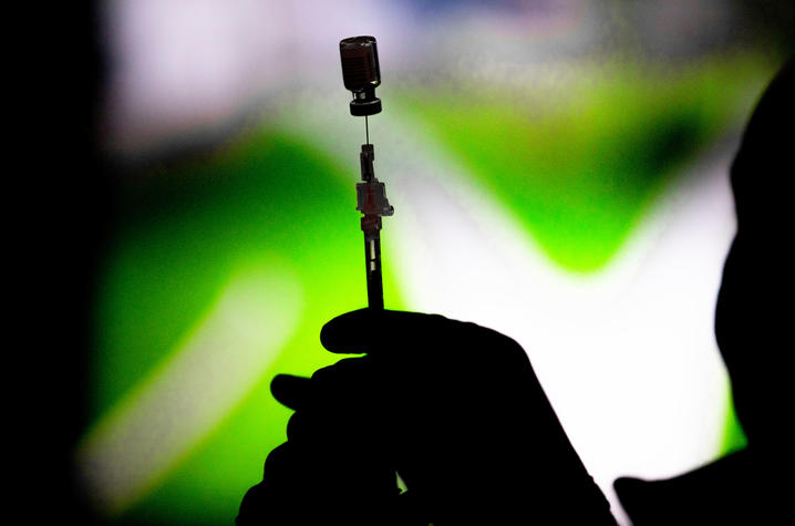 The COVID-19 vaccine being prepared at UK vaccination clinic at Kroger Field. Photo shows a person filling syringe with vaccine.