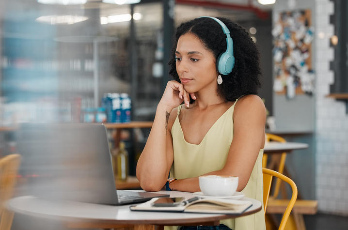 woman sitting in front of a laptop with headphones on