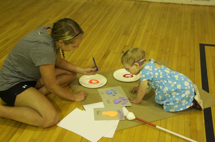 adult and child paint animal tracks on floor