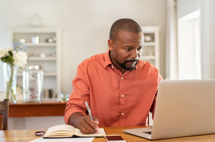 man working from home with laptop and phone