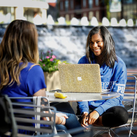 photo of two girls with laptop