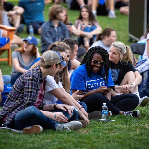 Photo of students sitting together on lawn