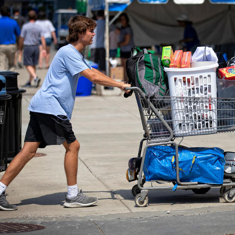 male student pushing a cart full of items for his residence hall at Move-In 2019