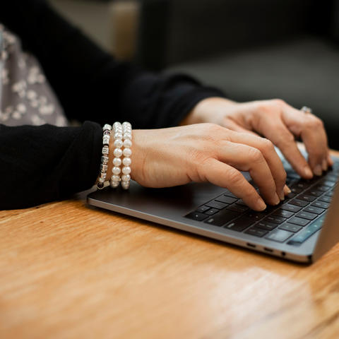 Photo of individual typing on laptop