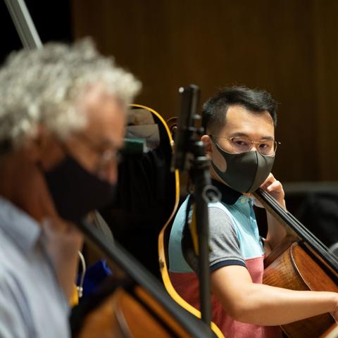 photo of masked Professor Benjamin Karp playing with 2 student musicians