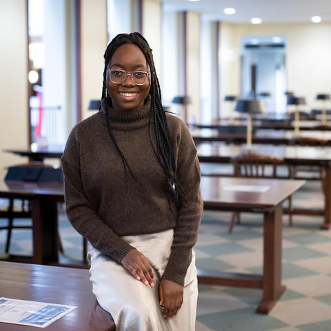 photo of Chimene Ntakarutimana seated on table in Young Library