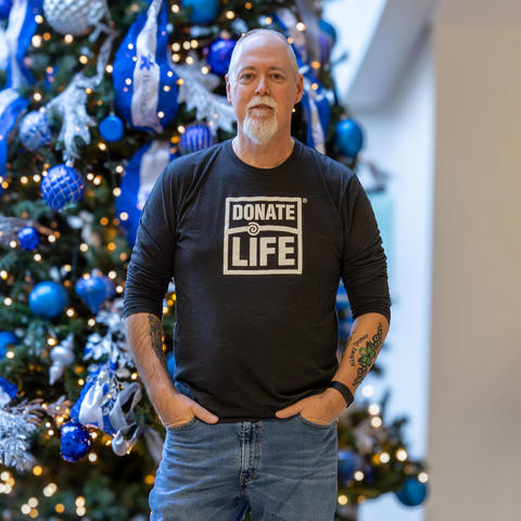 Image of Tom Coleman standing in front of a christmas tree