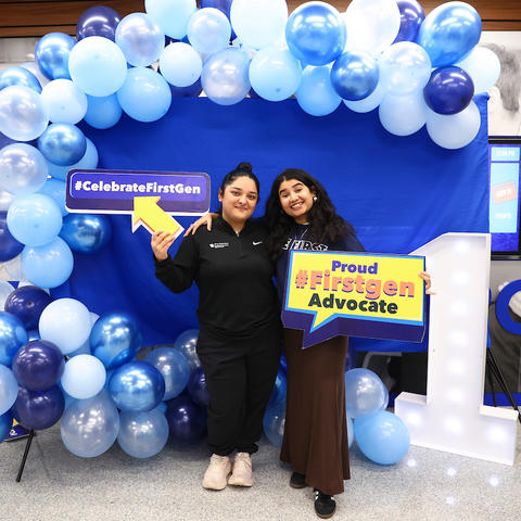 Students standing with first-gen signs 