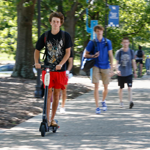 Student riding scooter. 