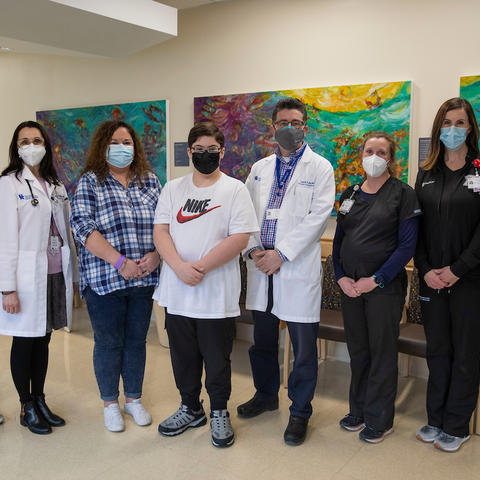 Image of 12-year-old Tyson with his care team in clinic