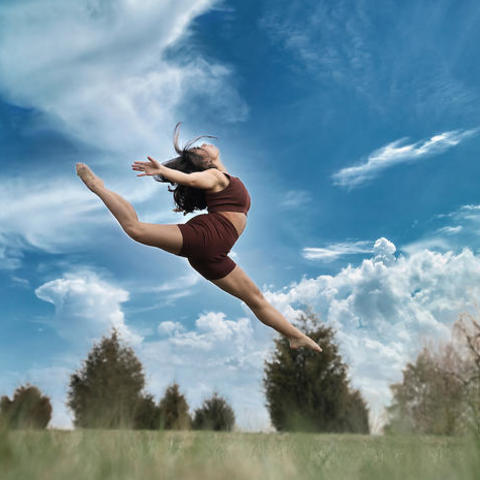 photo of dancer jumping in field