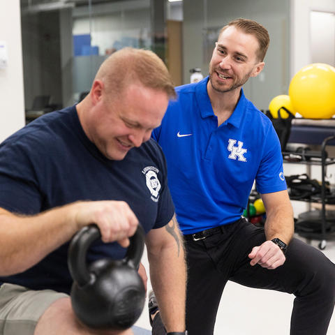 jake jelmini helping a firefighter with physical therapy