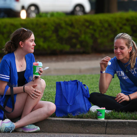 Students sitting eating snow cones. 